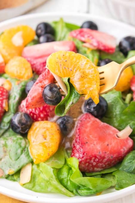 A bite of a strawberry spinach salad.